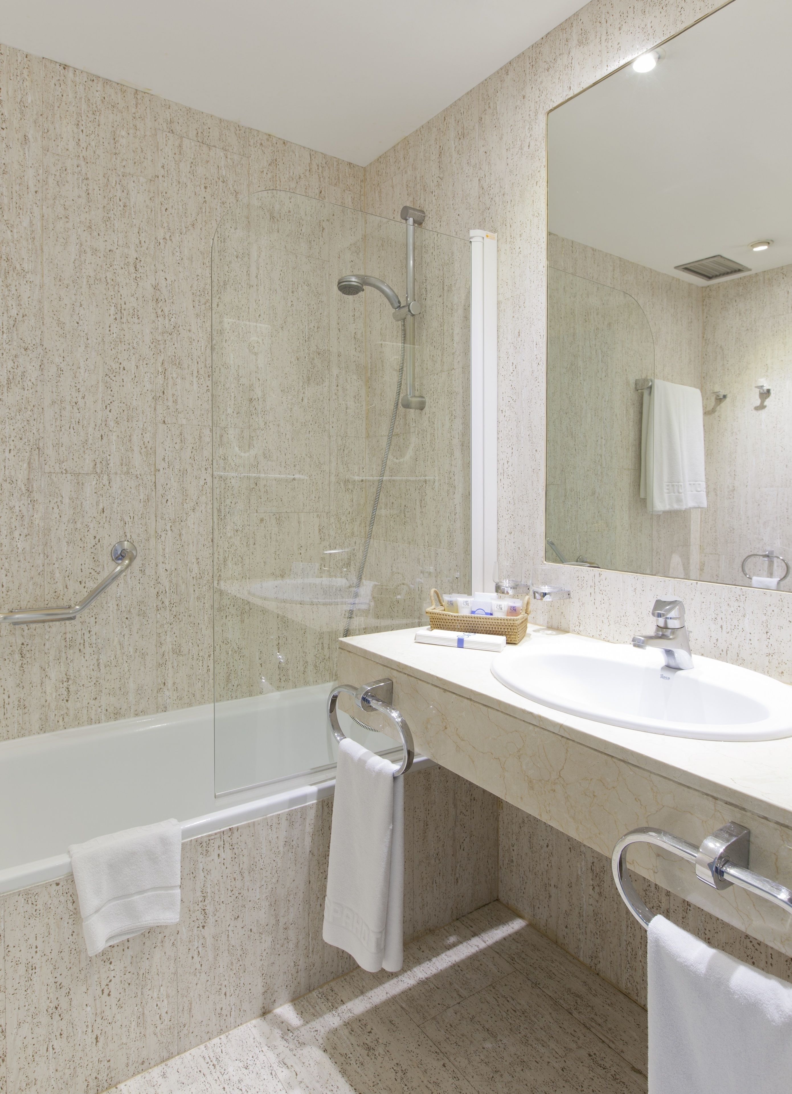 Un baño moderno con bañera, lavamanos y ducha.