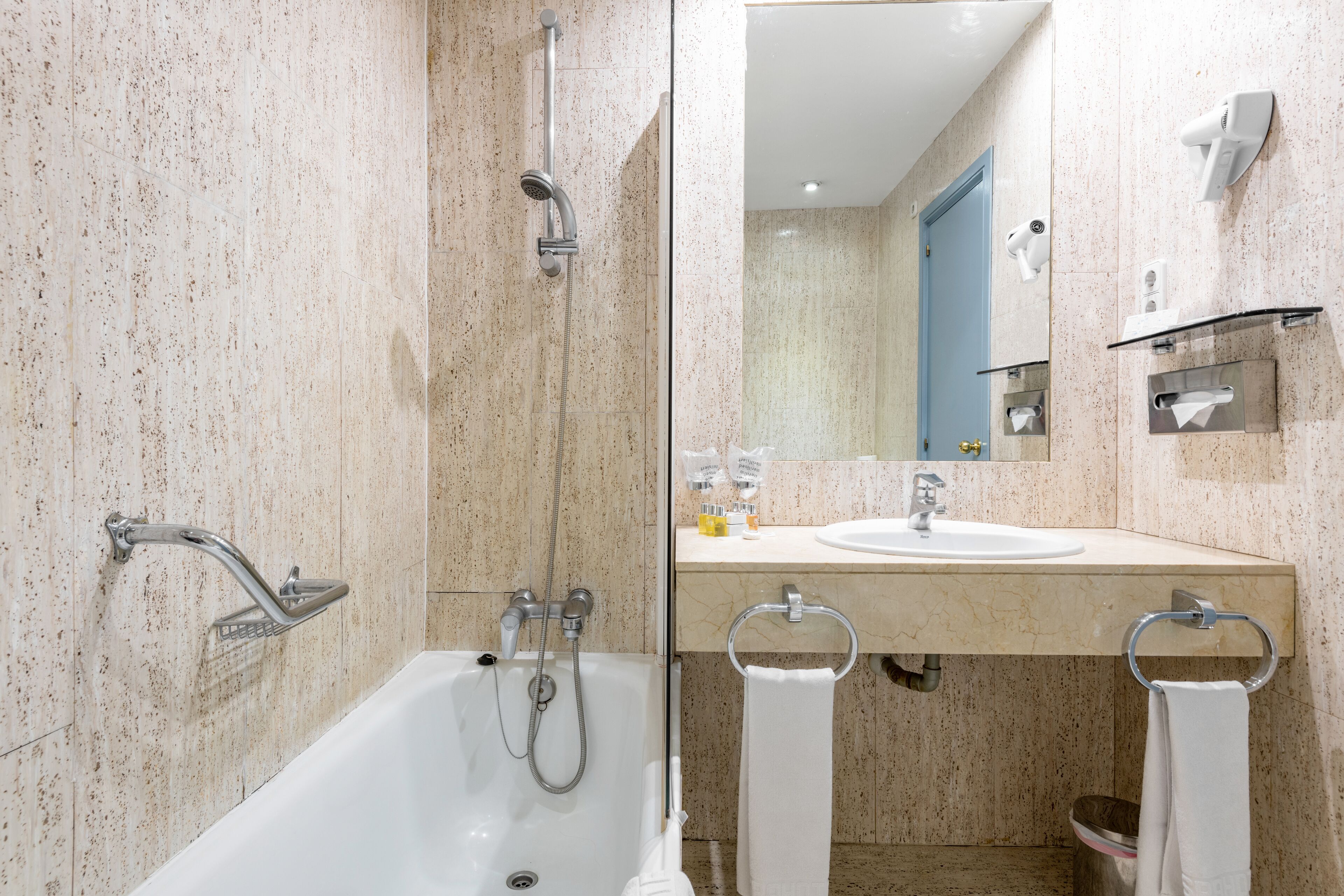 Un baño moderno con bañera, ducha, lavabo y espejo.