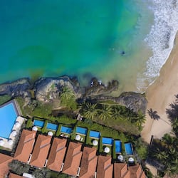 Enjoy beach access and pools from each bungalow, surrounded by lush greenery and palm trees.