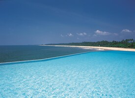 Una piscina al aire libre, sombrillas, sillones reclinables de piscina