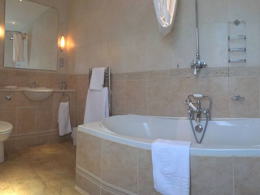 Un baño con bañera, lavabo e inodoro.
