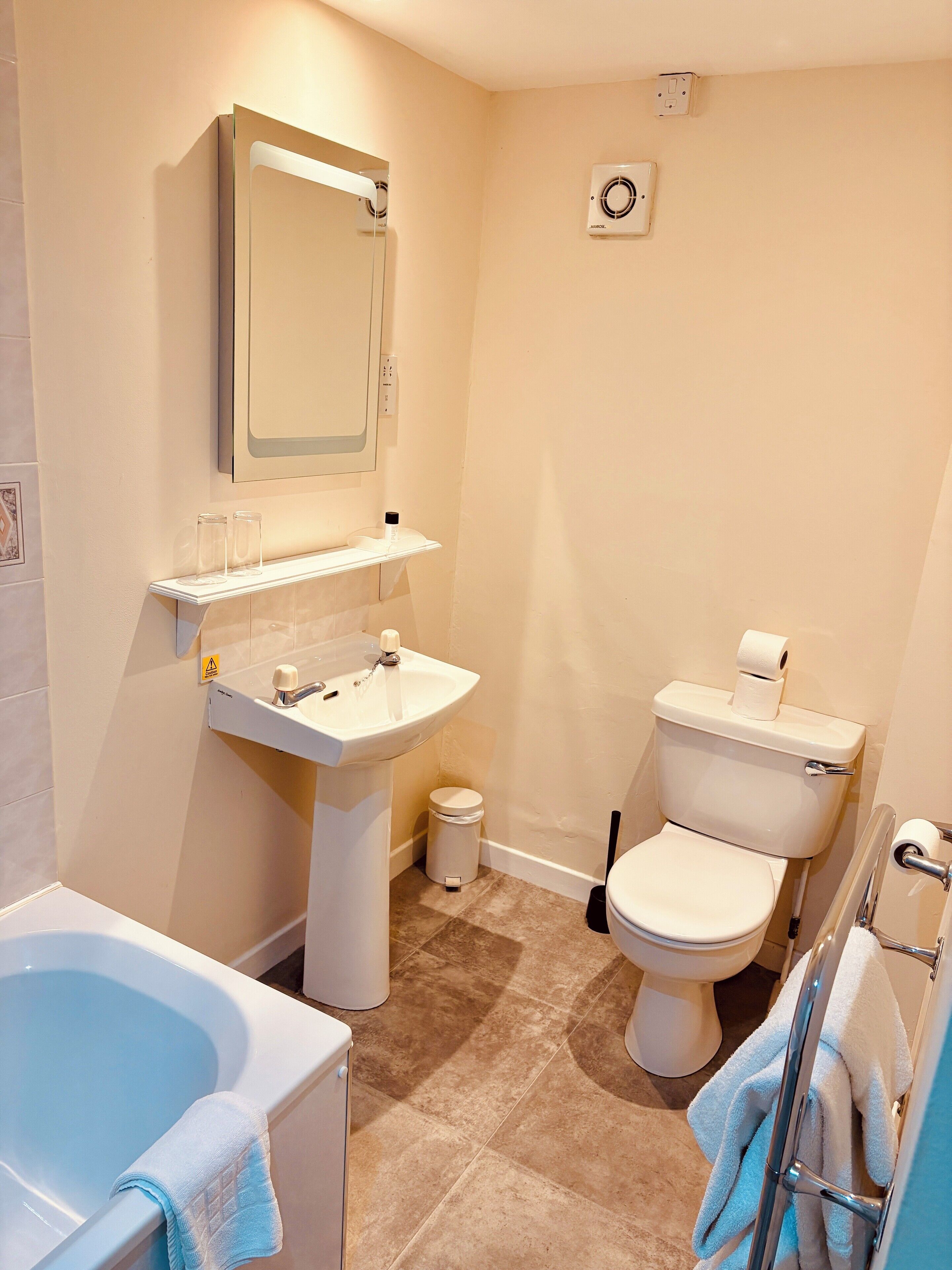 Une salle de bain avec une baignoire, un lavabo, des toilettes et un miroir.