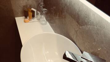 A bathroom with a white sink, chrome faucet, and a mirror above it.