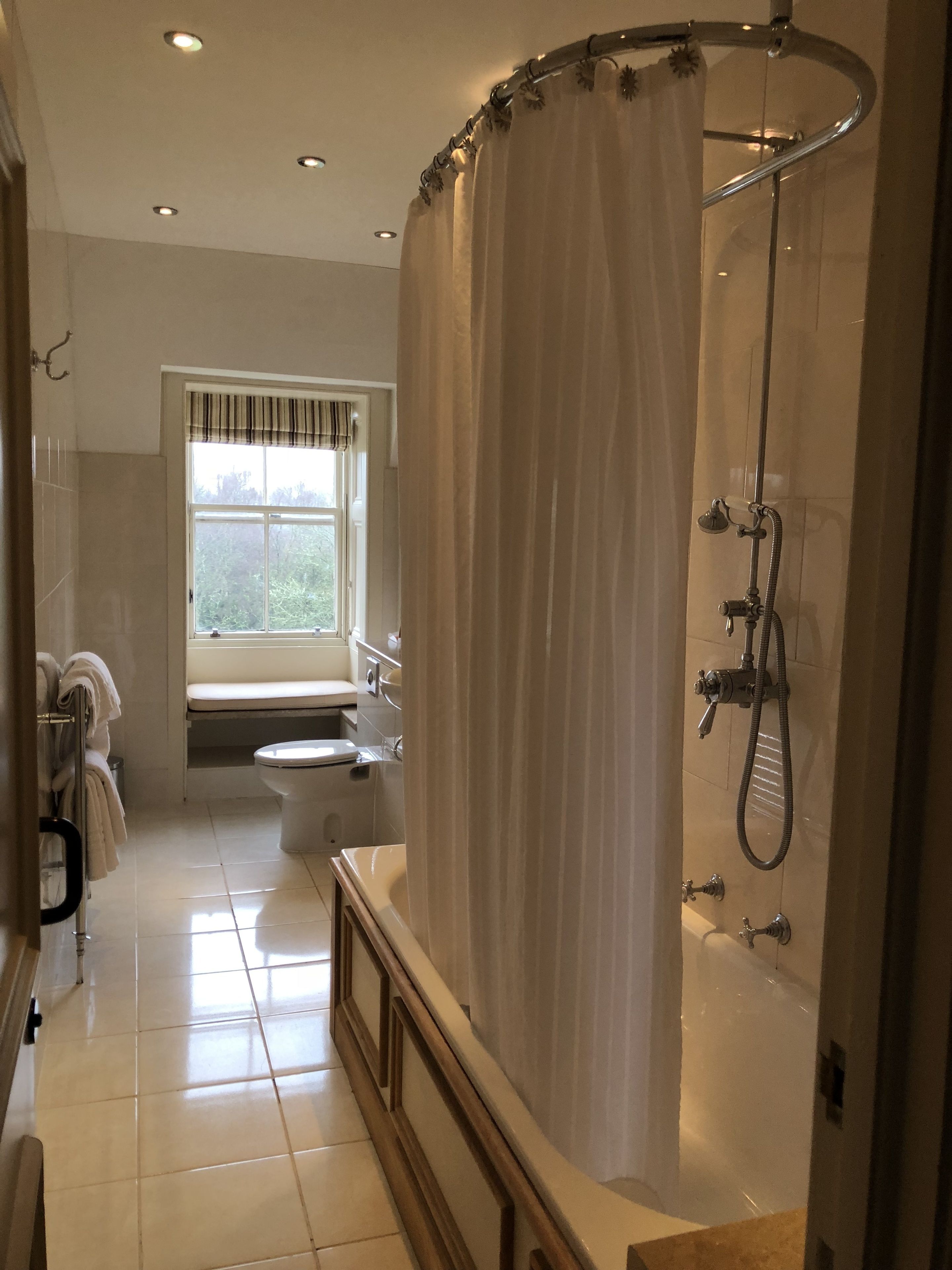 A modern bathroom with a shower, toilet, and sink.