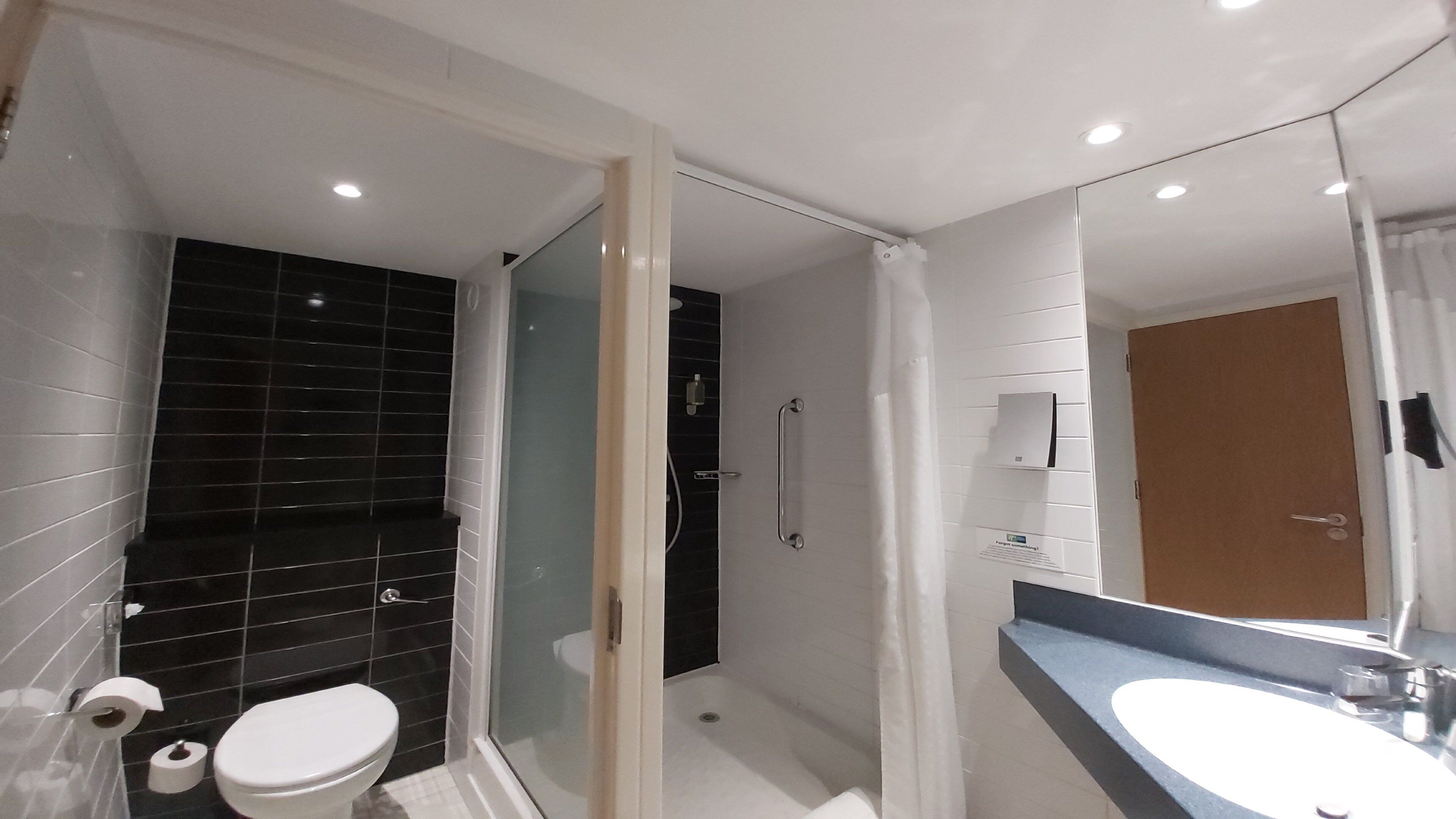 Un baño moderno con inodoro, ducha y lavamanos.
