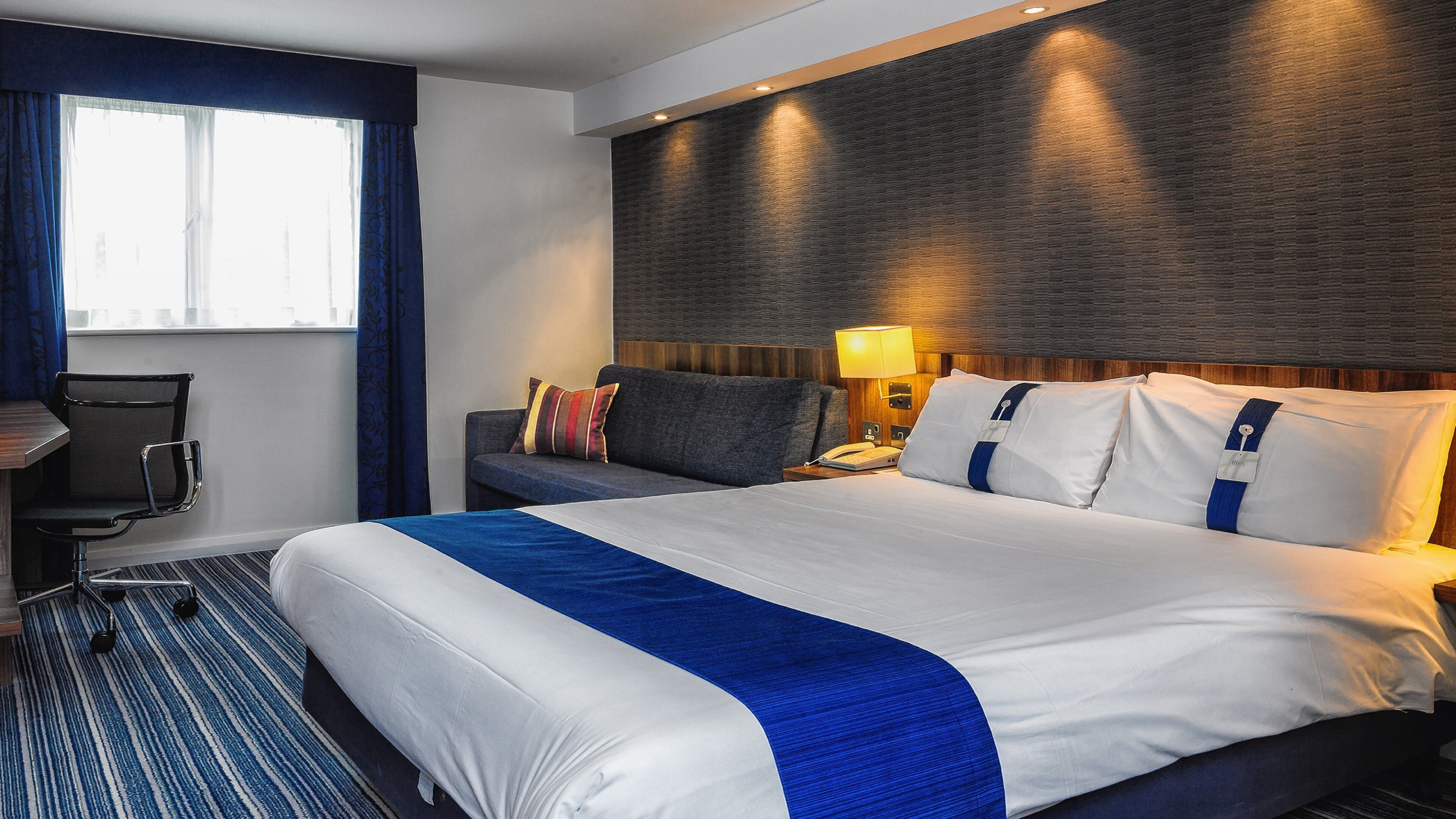 Una habitación de hotel con una cama grande, un escritorio y una silla.