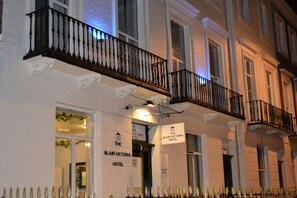 The exterior of The Blair Victoria Hotel with a classic facade, a balcony with ornate black railings, and signage indicating the hotel's name. - The Blair Victoria Hotel (London)