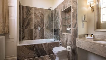 A bathroom with a bathtub, toilet, and a glass-enclosed shower area.