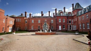 A large, red-brick building with a central courtyard, a fountain, and a statue. - Champneys Tring (Tring)