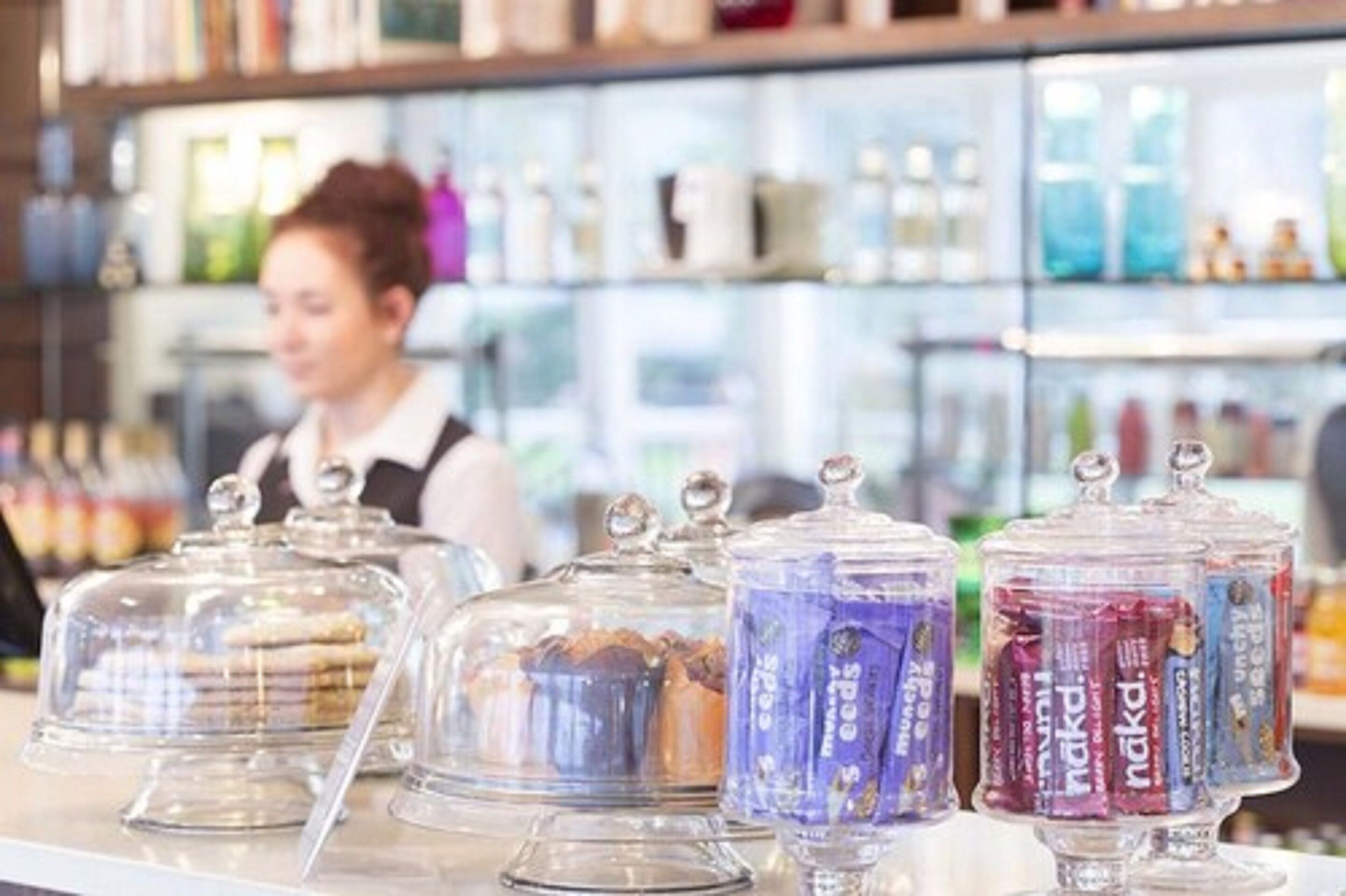 A bakery display with various baked goods under glass covers.