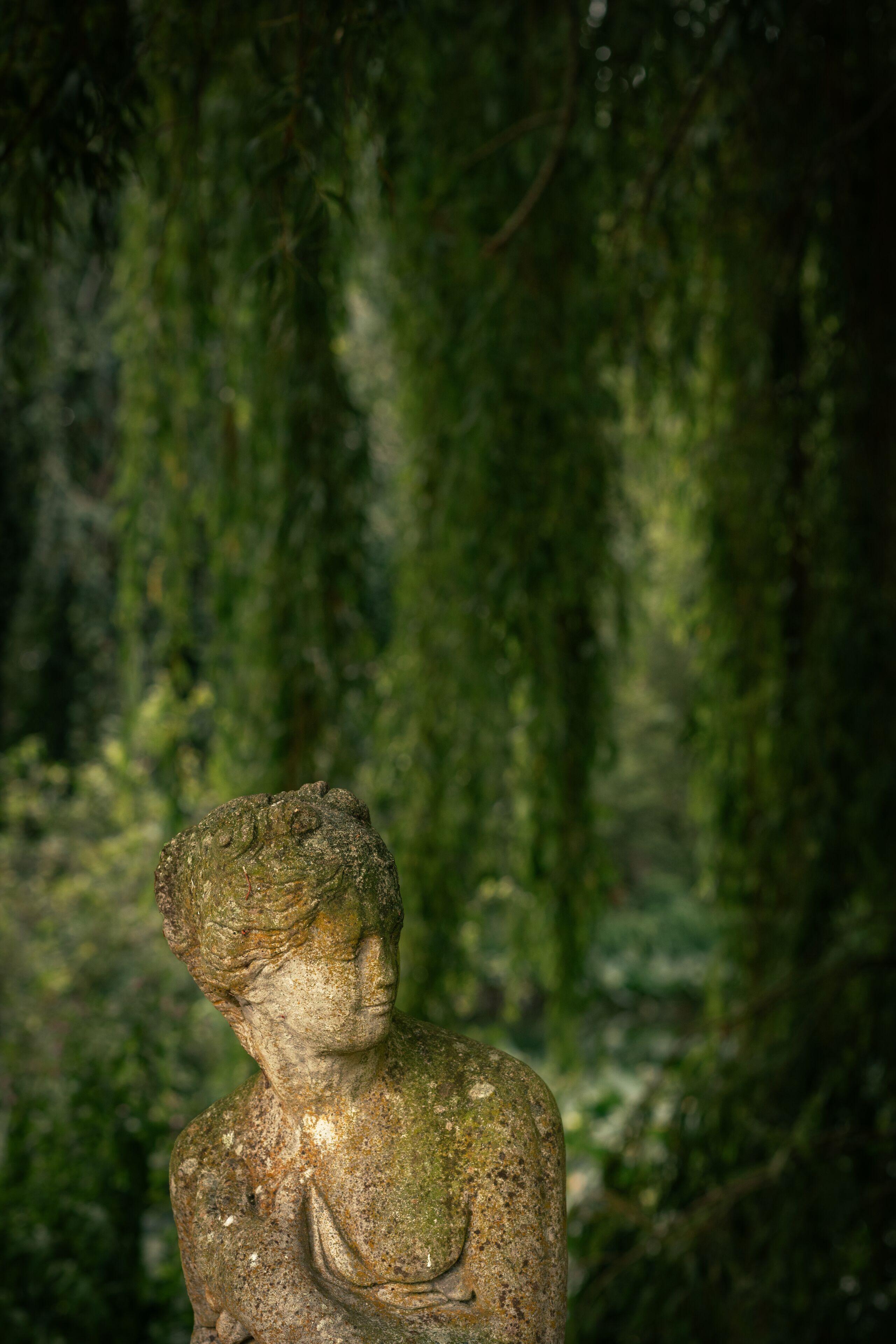 A stone statue in a forested area.