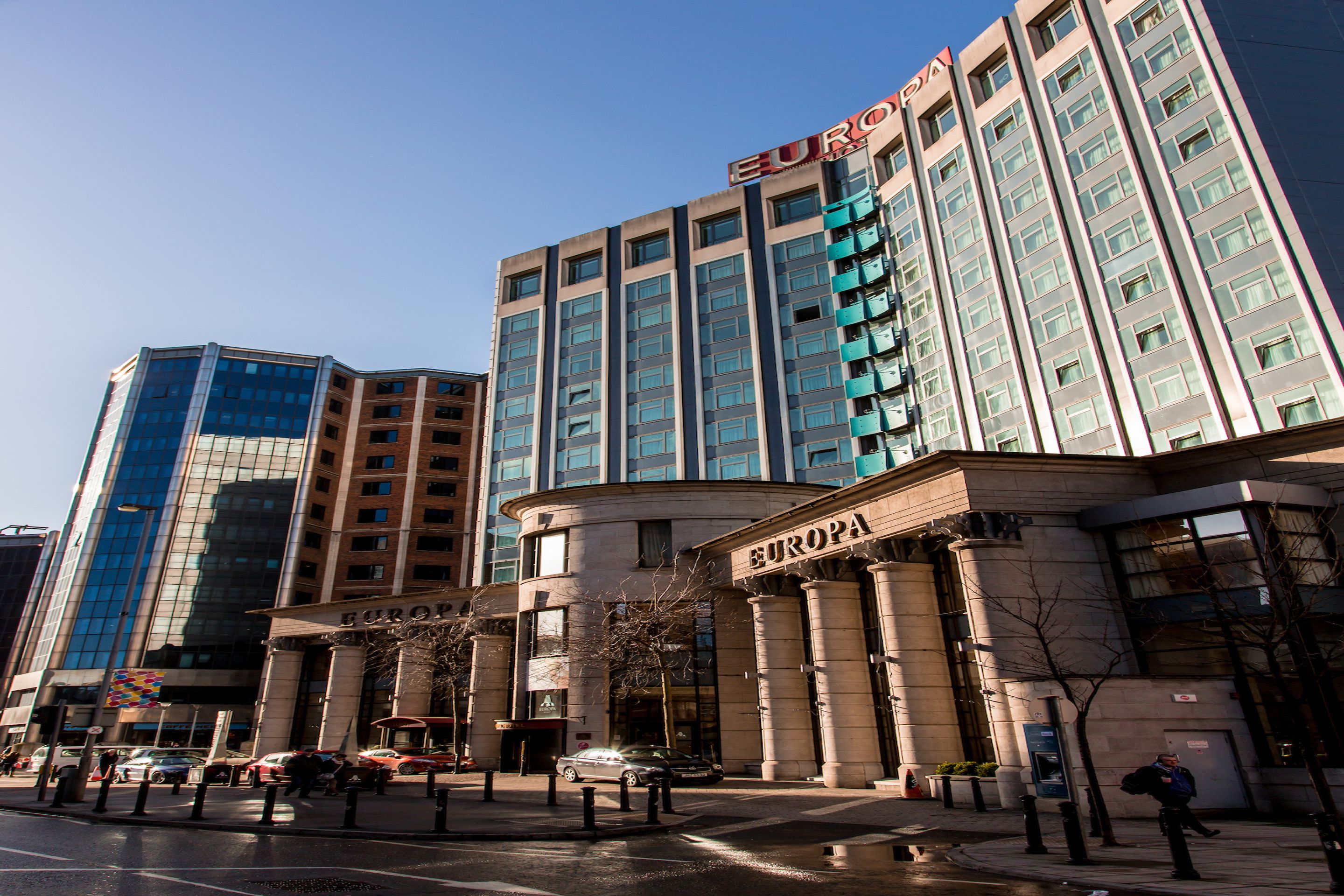 A modern hotel with a prominent 'EUROPA' sign, featuring a classical facade with columns and a large entrance.