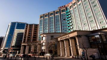 A modern hotel with a prominent 'EUROPA' sign, featuring a classical facade with columns and a large entrance.