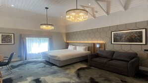 A modern hotel room with a large bed, a sofa, and two pendant lights. - London Chigwell Prince Regent Hotel, BW Signature Collection (Woodford Green)