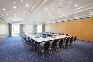 A conference room with a long table, chairs, and a whiteboard.