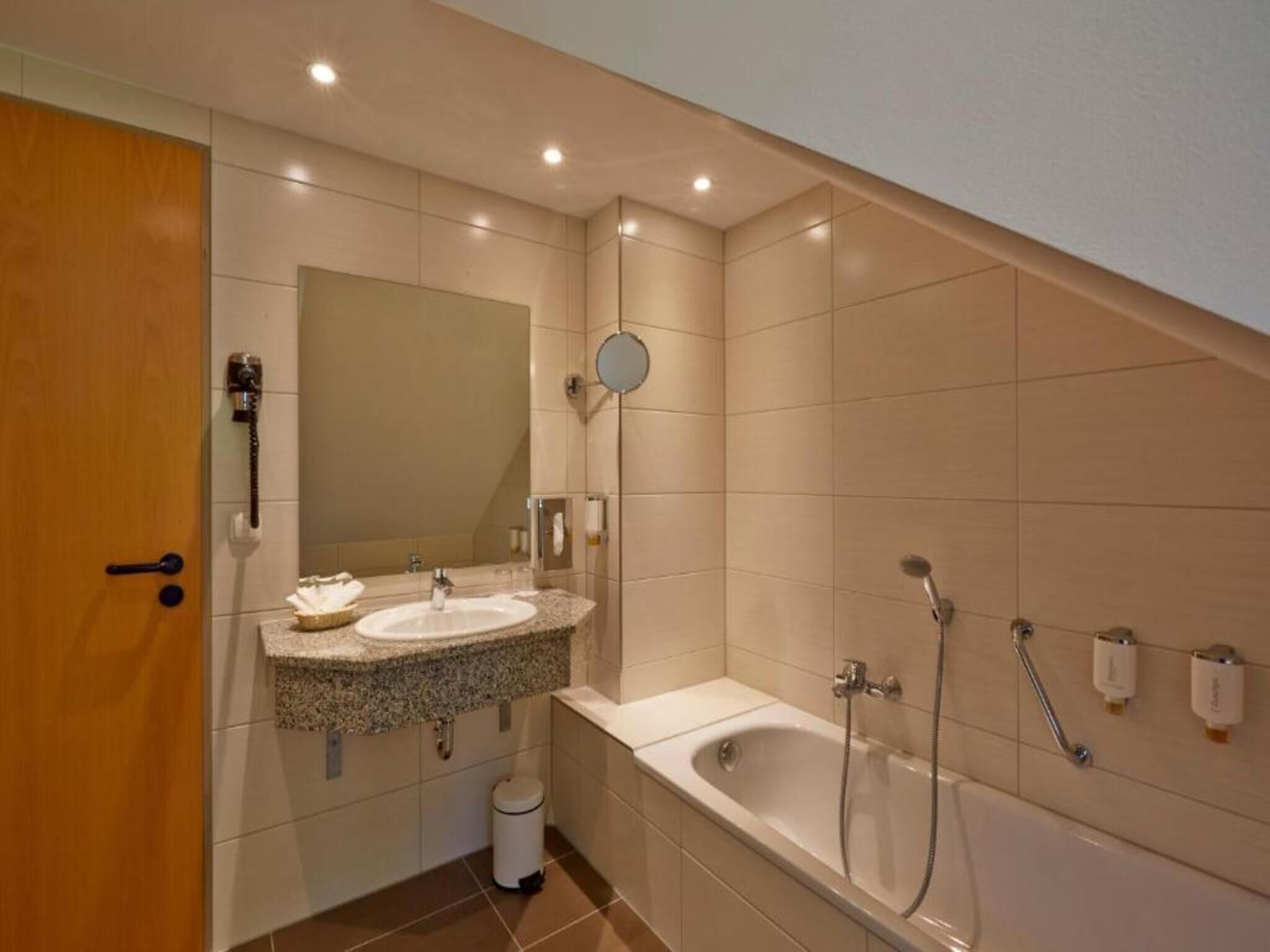 Une salle de bain moderne avec un meuble-lavabo à deux vasques, un grand miroir, une baignoire et un espace douche.