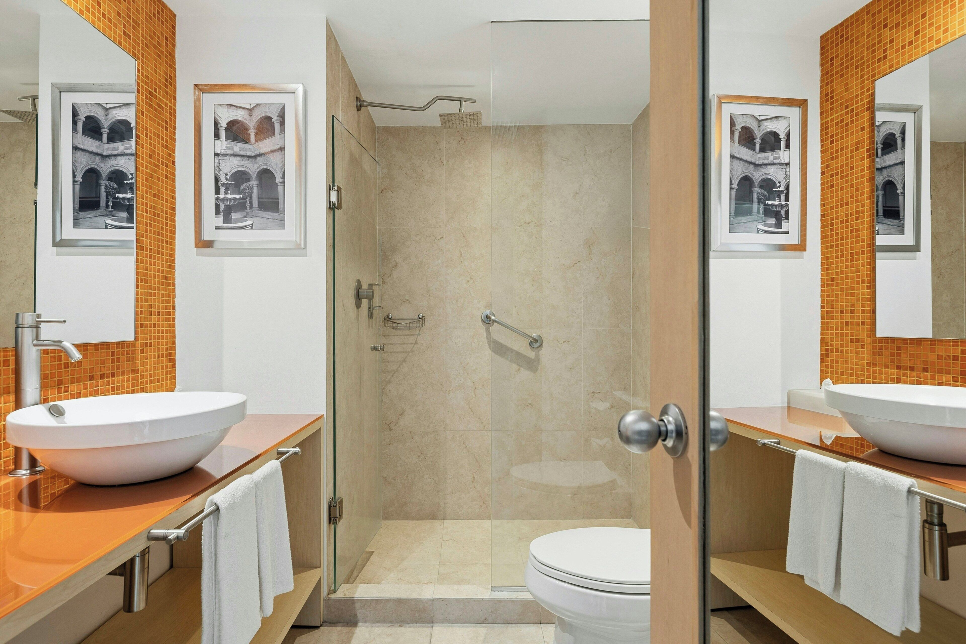 Un baño con dos lavamanos, un inodoro y una ducha.
