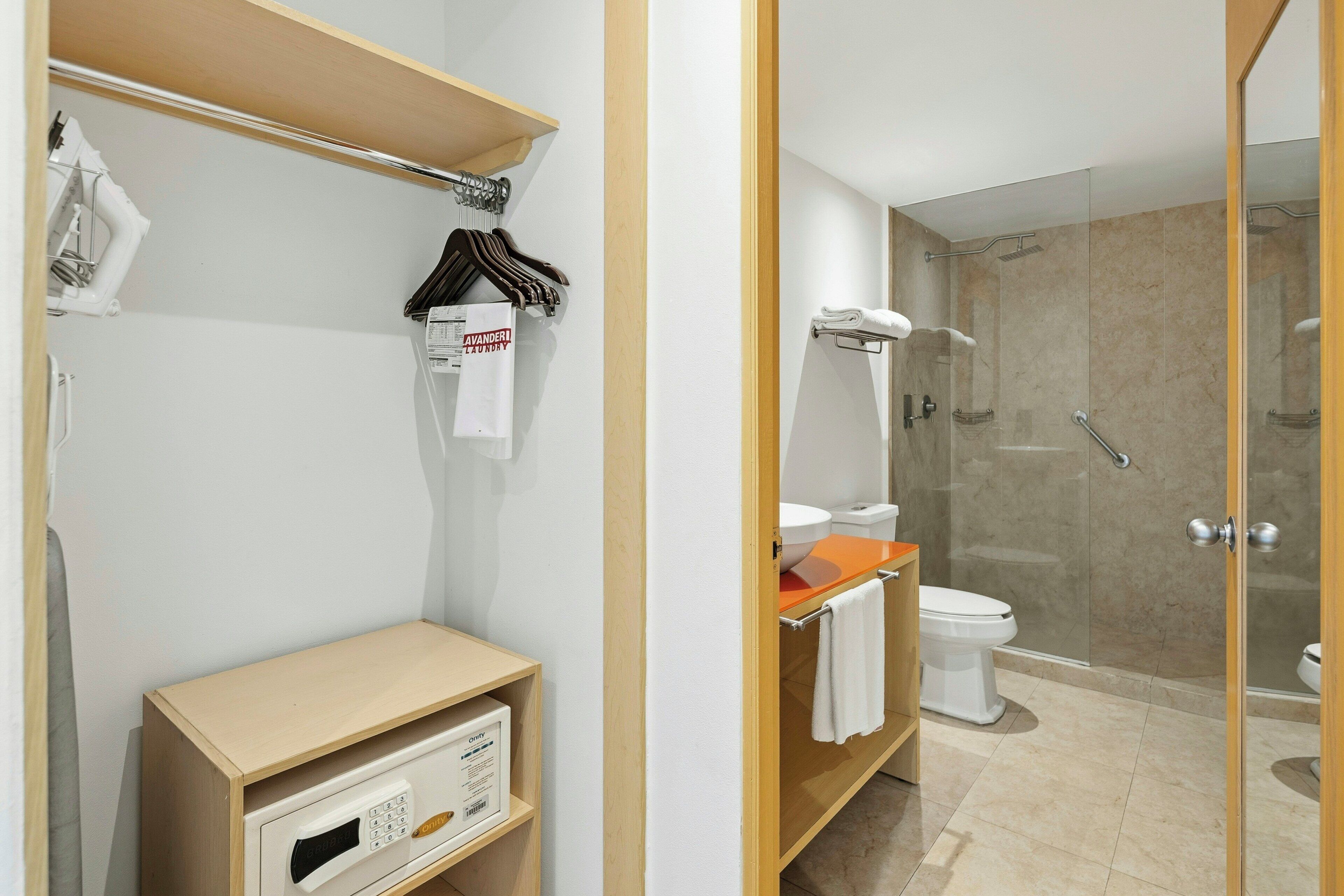 Un baño moderno con ducha, inodoro y tocador con espejo.