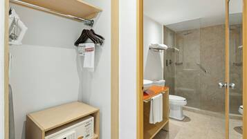 Un baño moderno con ducha, inodoro y tocador con espejo.