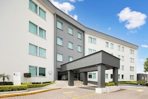 A modern hotel with a covered entrance, multiple floors, and a clear sky. - Fiesta Inn Express Perinorte (Tultitlan)