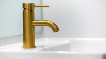 Un grifo dorado sobre un lavabo blanco.