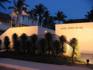 A building with a sign reading 'HOTEL PORTO DO SOL' and palm trees in front. - Porto Do Sol Hotel (GUARAPARI)