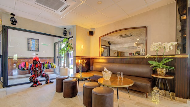 A lobby with a reception desk, seating area, and a large mirror. - Eurotel (Perols)