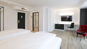 A hotel room with a bed, a desk, a chair, and a TV. - DORMERO Hotel Meerbusch (Meerbusch)