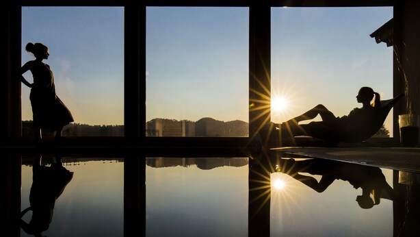 Una habitación con un ventanal grande que refleja el sol y el contorno de una persona.