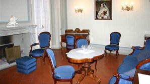 Un comedor formal con una mesa redonda, sillas tapizadas en azul y una chimenea.