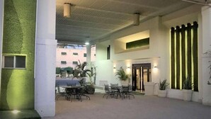 An indoor courtyard with a seating area, a staircase, and a door leading to another section. - Quality Inn Ciudad Obregon (Cajeme)