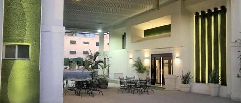 An indoor courtyard with a seating area, a staircase, and a door leading to another section.