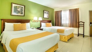A hotel room with two beds, green walls, and a wooden headboard. - Quality Inn Ciudad Obregon (Cajeme)