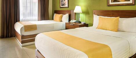 A hotel room with two beds, a nightstand with a lamp, a telephone, and a framed picture on the wall.