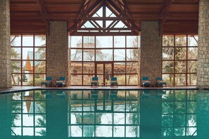 Una piscina techada, una piscina al aire libre de temporada, sombrillas
