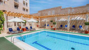 Piscine extérieure, parasols de plage, chaises longues