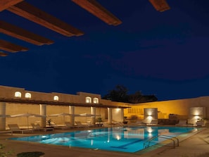 Een buitenzwembad, parasols voor strand/zwembad