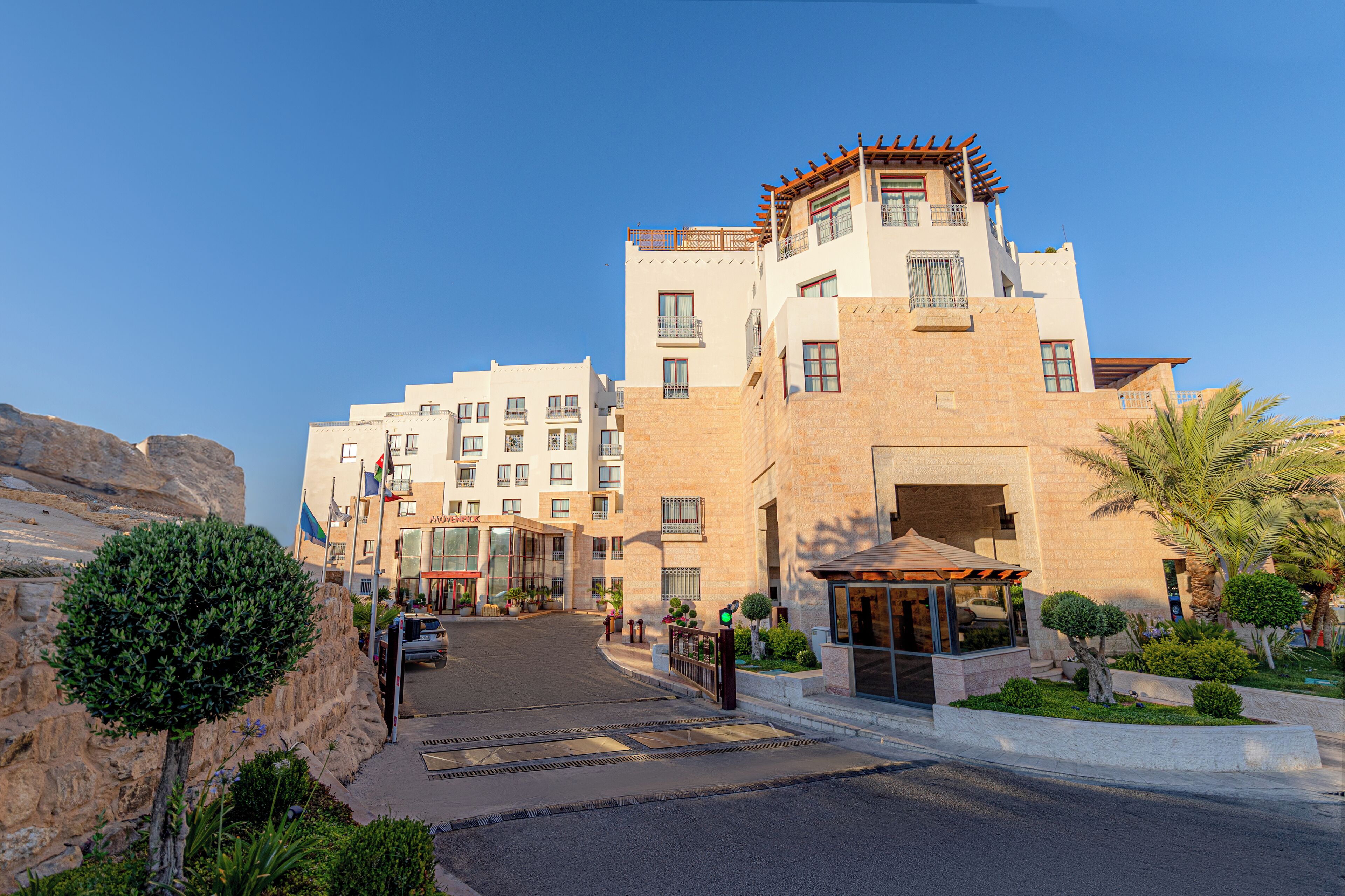 Un hotel de varios pisos con un diseño arquitectónico moderno, que cuenta con balcones y ventanas amplias.