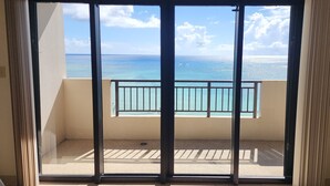 A balcony with a view of the ocean and a clear sky. - Aquarius Beach Tower (Saipan)