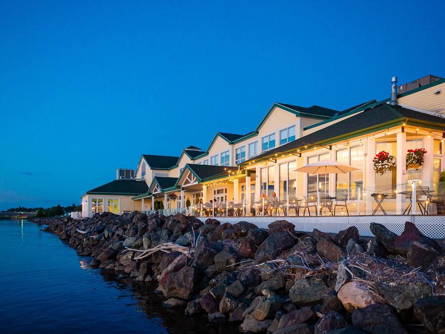 Un hotel frente al mar con terraza y vistas al agua.