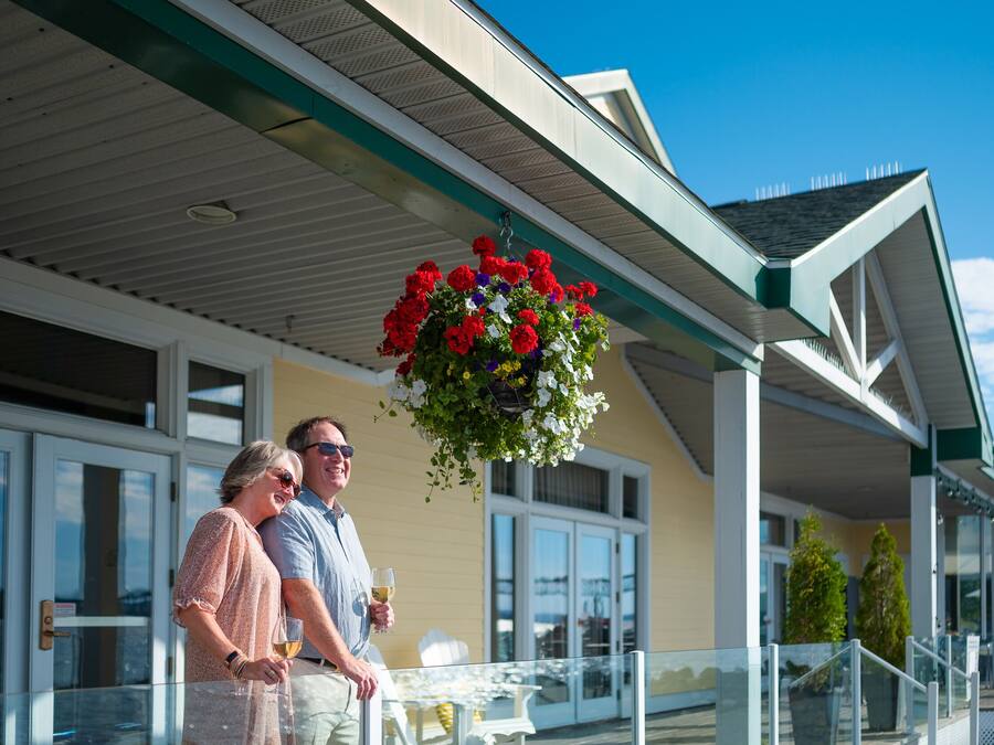 Un bâtiment doté d’un patio couvert, d’un espace extérieur aménagé pour s’asseoir et d’une jardinière suspendue.