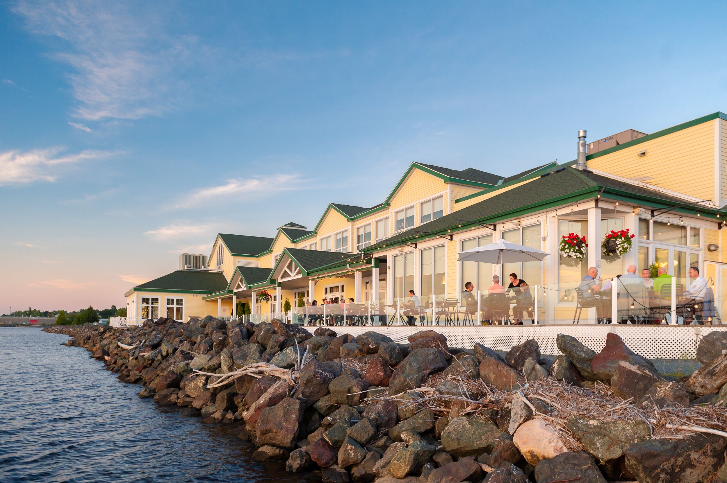A waterfront restaurant with outdoor seating and a view of the water.