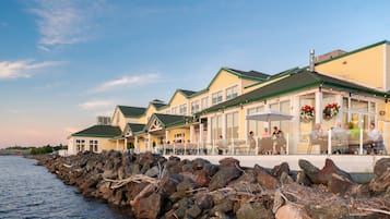 A waterfront restaurant with outdoor seating and a view of the water.