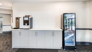 A kitchenette with a coffee machine, a refrigerator, and a beverage dispenser. - Days Inn by Wyndham Valemount (Valemount)