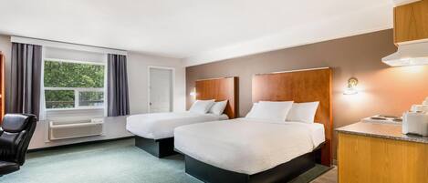 A hotel room with two beds, a desk, a chair, and a window with curtains.