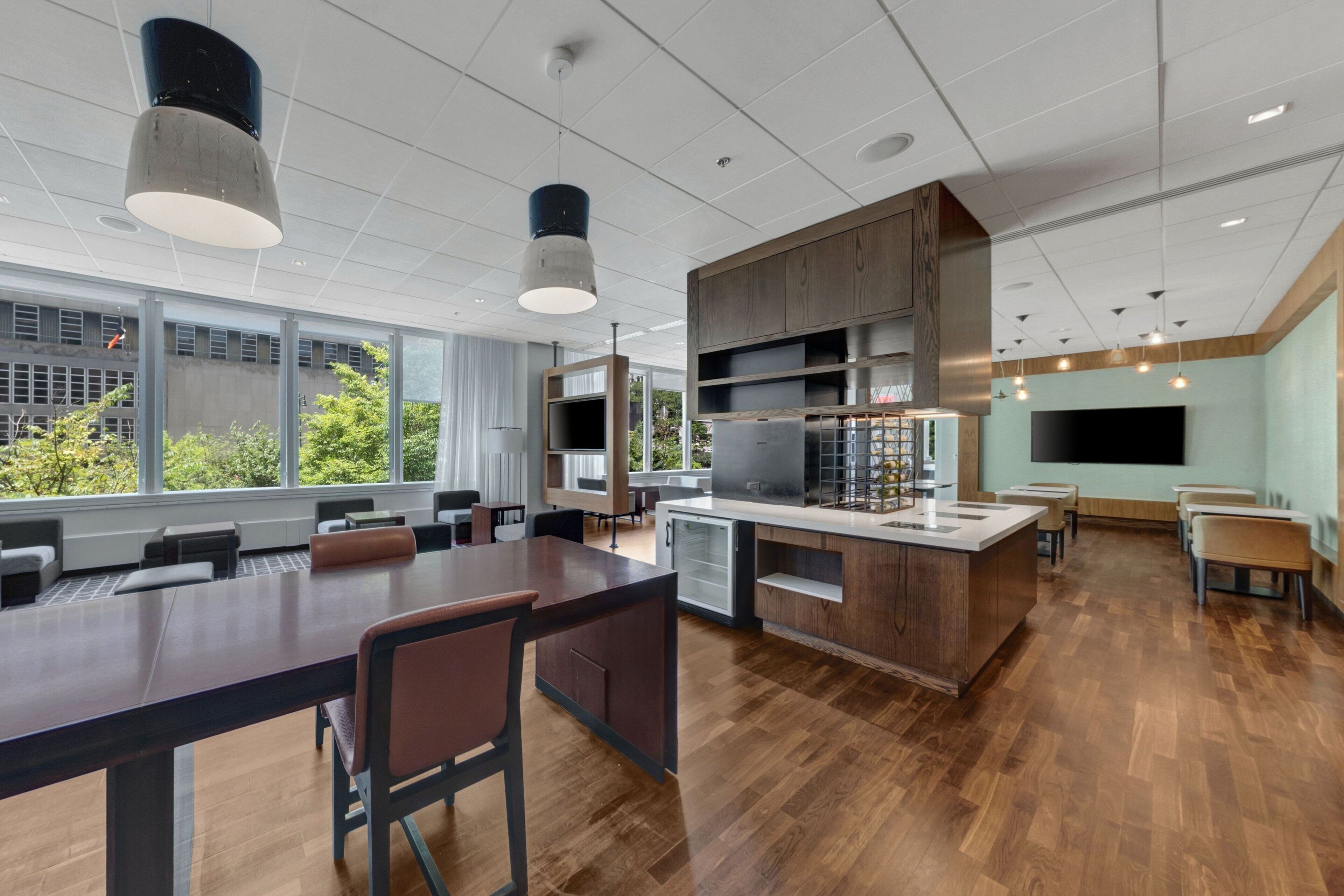 A modern kitchen with a central island, built-in cabinets, and a large flat-screen TV.