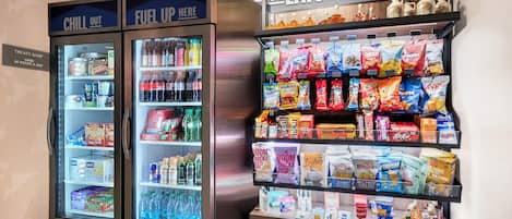 A vending machine with a variety of snacks and beverages, including chips, sodas, and energy drinks.