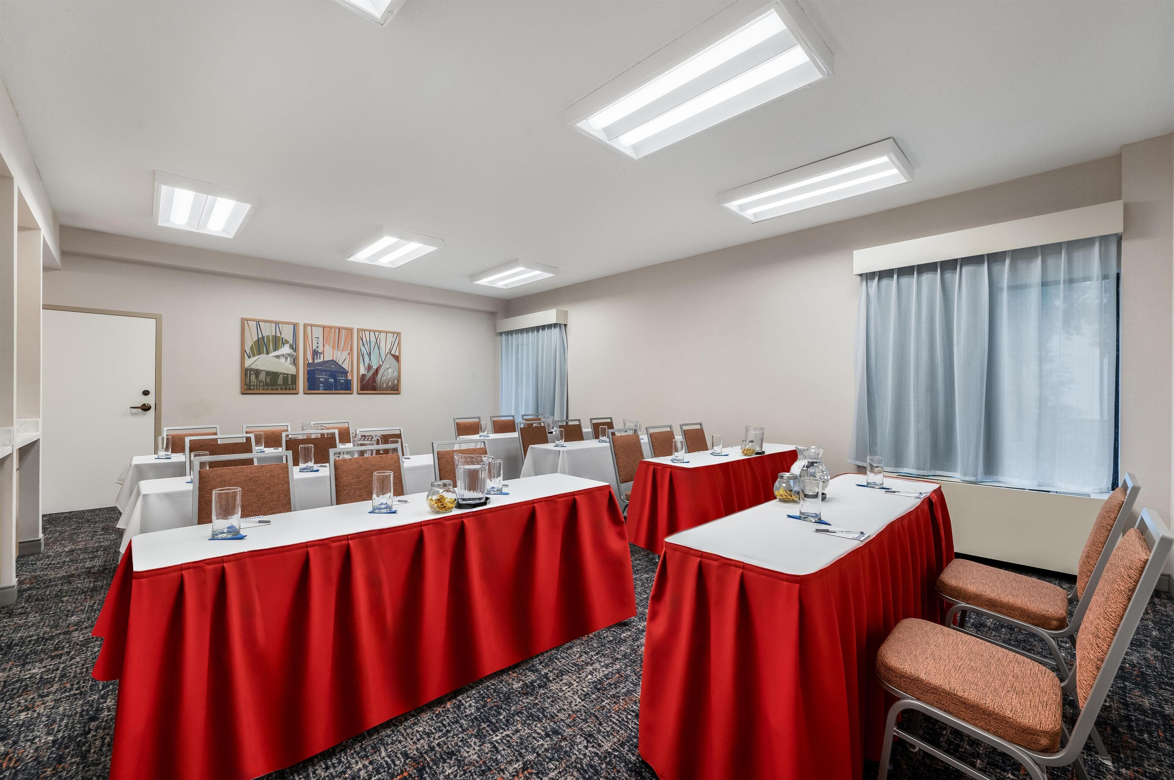 Una sala conferenze con tavoli, sedie e opere d'arte alle pareti.