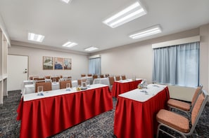 Una sala de conferencias con mesas, sillas y obras de arte en la pared.