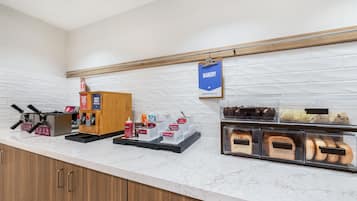 Mostrador de panadería con diferentes productos horneados y una estación de gofres.
